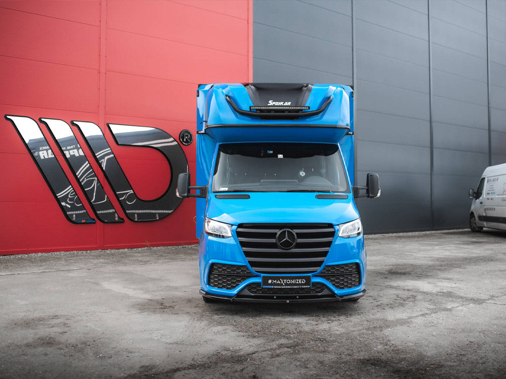 Black front splitter for Mercedes-Benz Sprinter Mk3 by MAXTON® DESIGN, mounted on the vehicle's front bumper for enhanced styling.